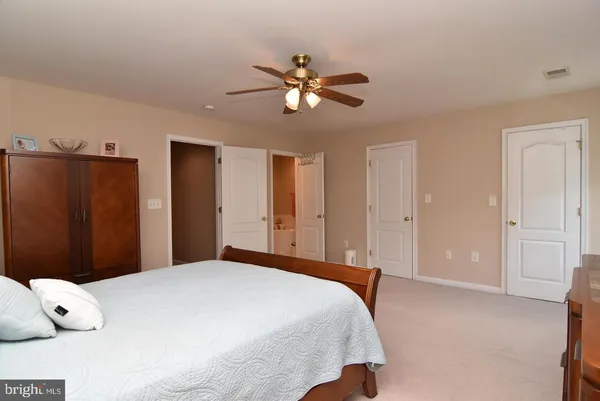 a bedroom with a large bed and a chandelier