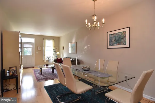 a living room with couches a table and chairs with wooden floor