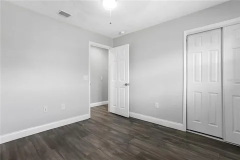 a view of an empty room with wooden floor