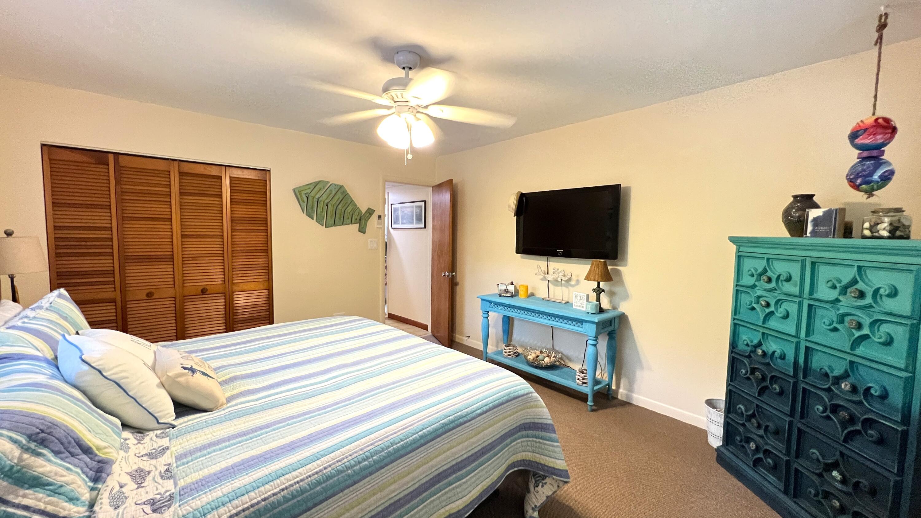 205 Sunset Boulevard Key Largo, FL 33037 - Photo 30 of 42 a bedroom with a bed and a flat tv screen on dresser