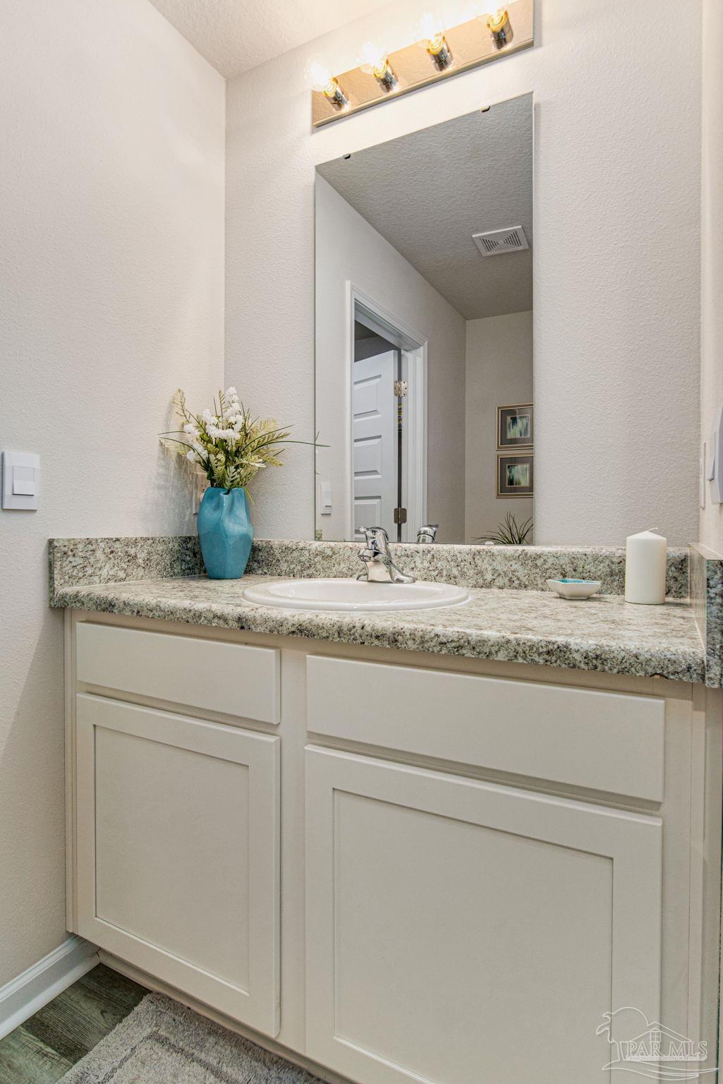 6461 Firefly Drive Milton, FL 32583 - Photo 16 of 36 a bathroom with a granite countertop sink and a mirror