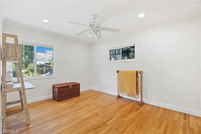 a view of a livingroom with wooden floor and a ceiling fan