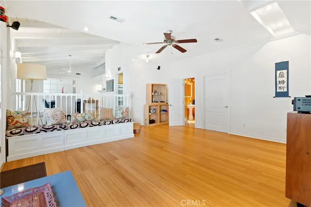 a view of a livingroom with furniture wooden floor and a ceiling fan