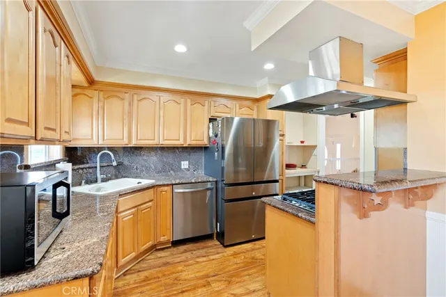 a kitchen with stainless steel appliances granite countertop a sink a stove and a refrigerator