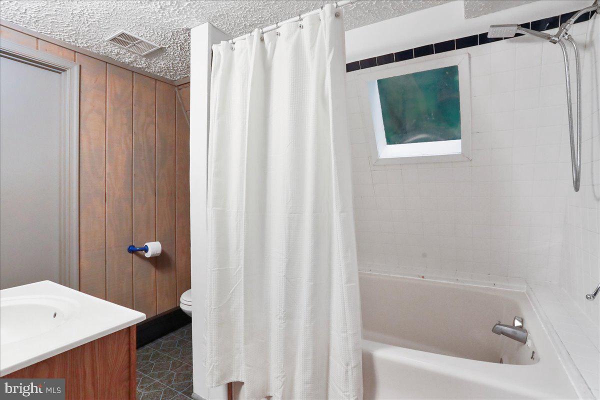 13 Mountainside Loop Berkeley Springs, WV 25411 - Photo 18 of 57 a bathroom with a shower curtain and a sink