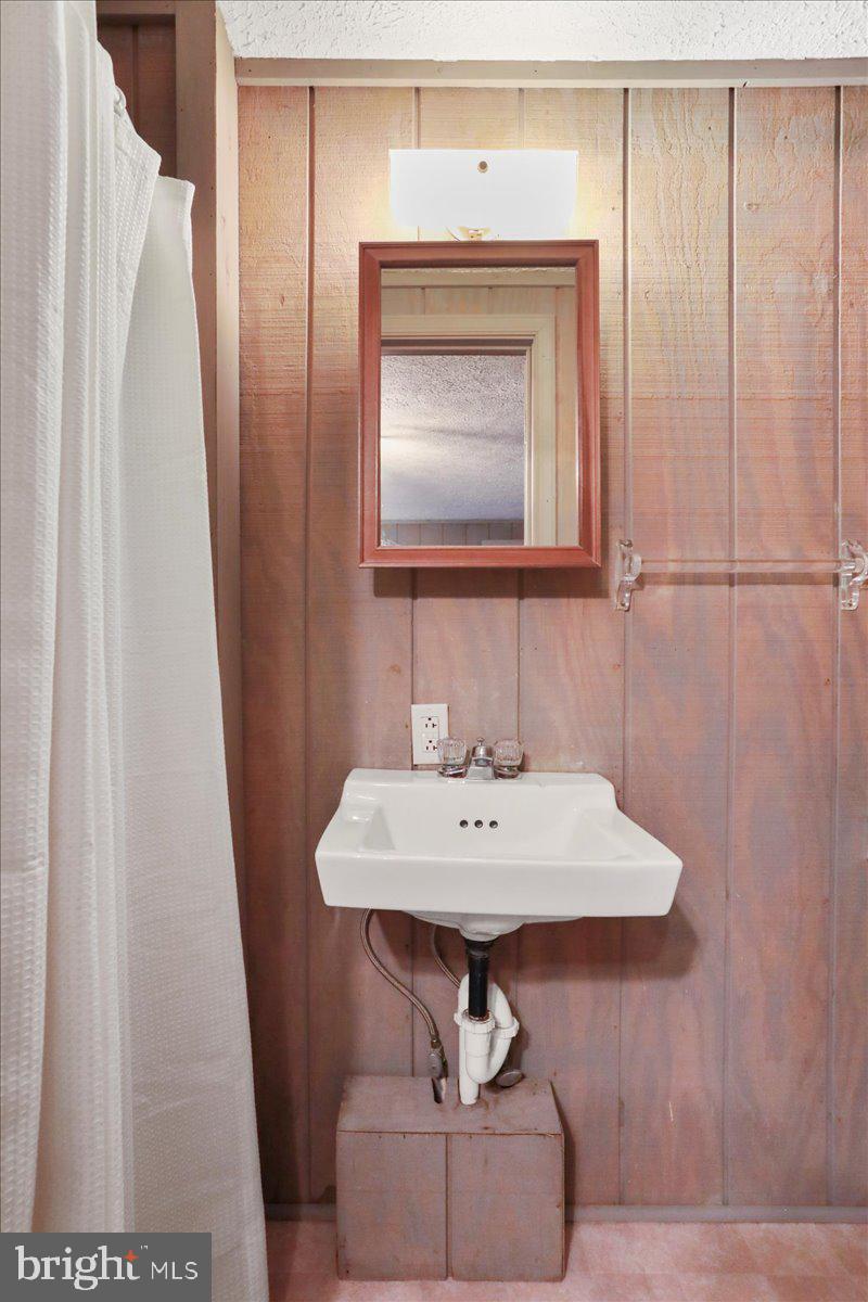 13 Mountainside Loop Berkeley Springs, WV 25411 - Photo 35 of 57 a bathroom with a sink a mirror and bathtub