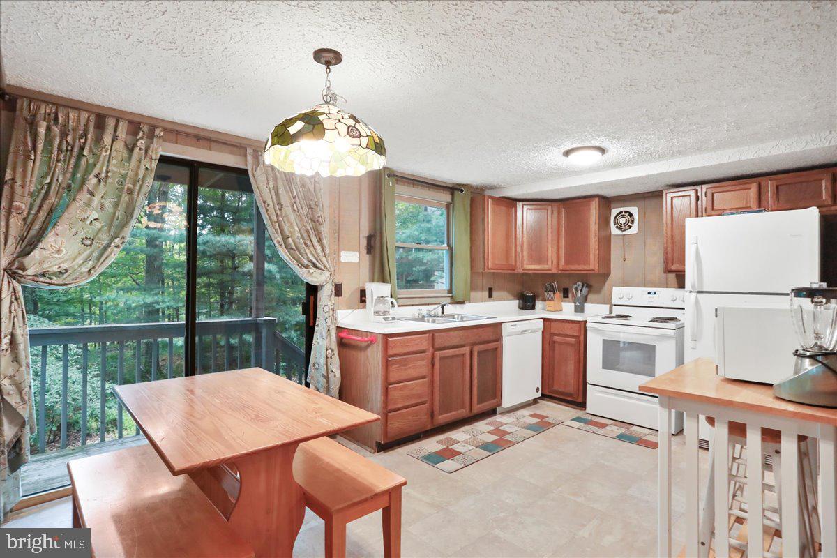 13 Mountainside Loop Berkeley Springs, WV 25411 - Photo 4 of 57 a kitchen that has a lot of white cabinets a sink and a stove