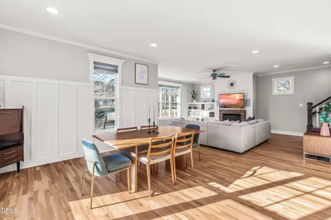 a living room with furniture a flat screen tv and a wooden floor