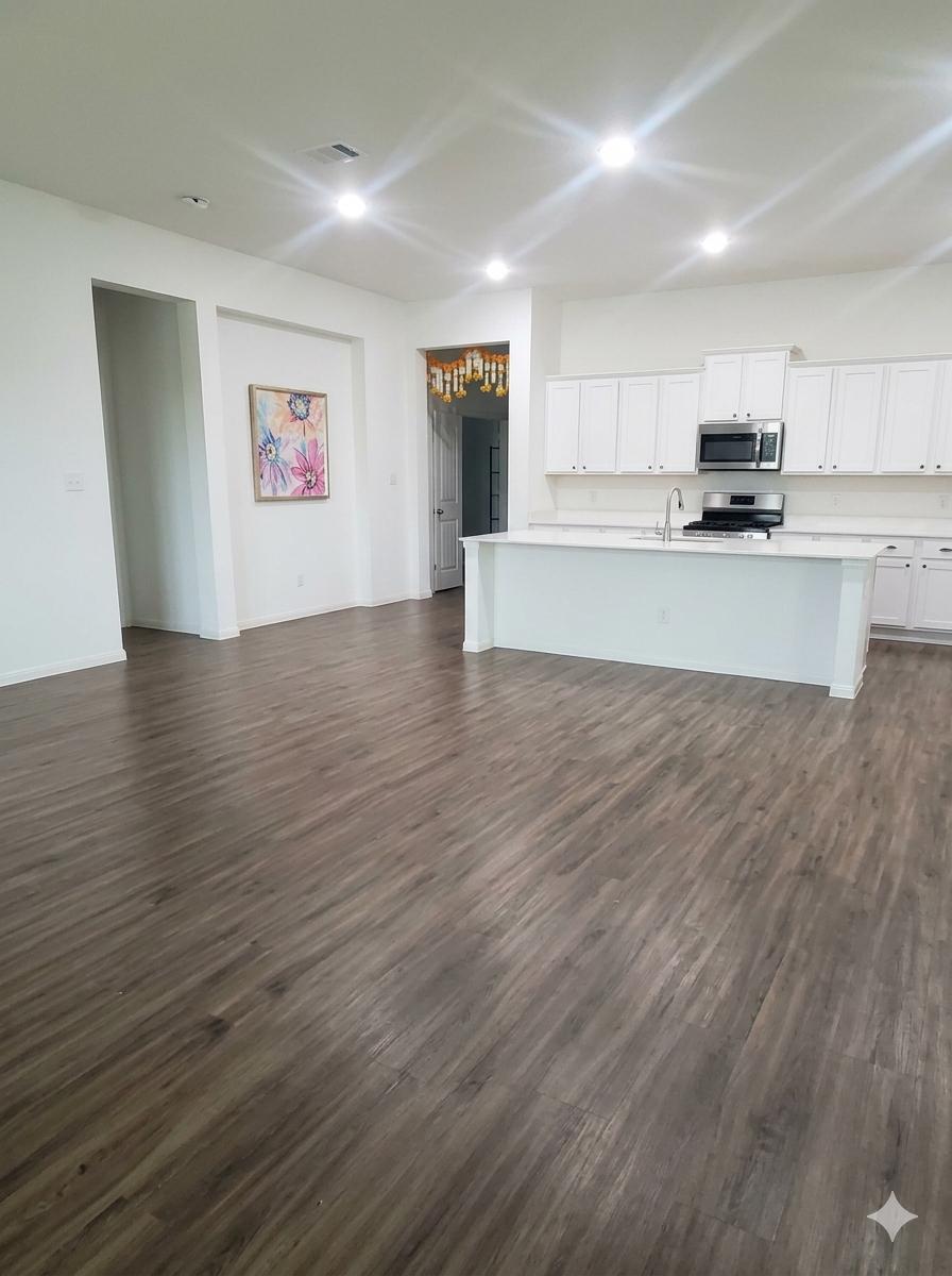 152 Venti Cove Georgetown, TX 78628 - Photo 3 of 16 a view of kitchen with kitchen island wooden floors and stainless steel appliances