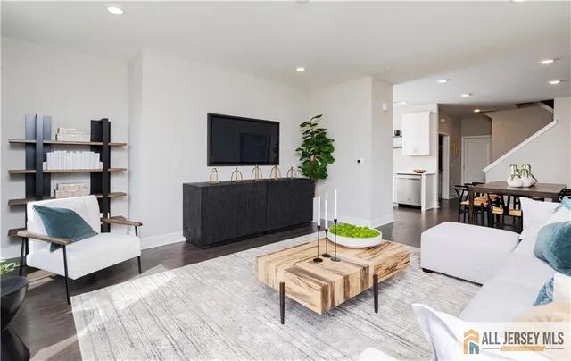 a living room with furniture a flat screen tv and a table