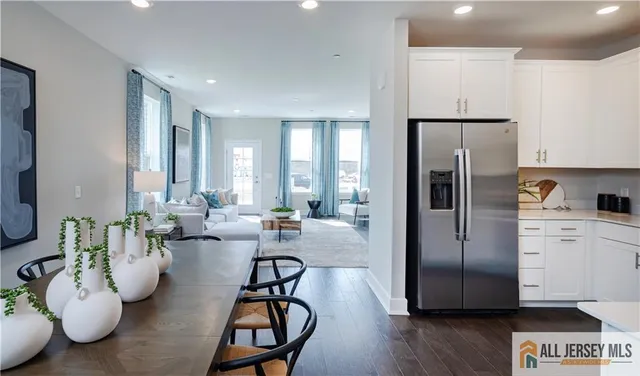 a kitchen with a refrigerator and white cabinets
