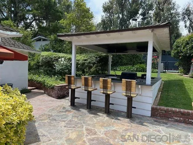 a view of patio with table and chairs potted plants with large tree