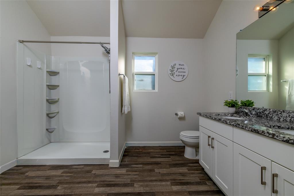 953 Ben Drive Springtown, TX 76082 - Photo 25 of 38 a bathroom with a granite countertop shower a toilet and a sink