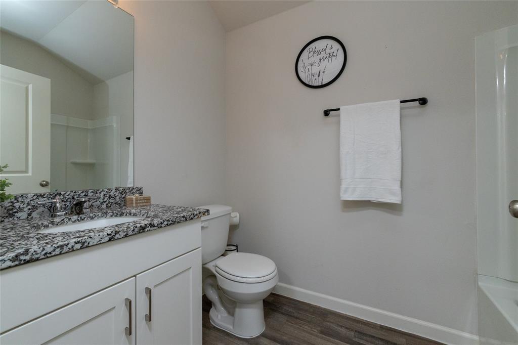 953 Ben Drive Springtown, TX 76082 - Photo 7 of 38 a bathroom with a granite countertop toilet sink and mirror