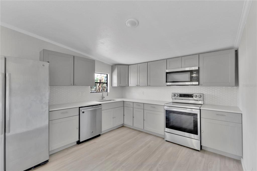 9180 Concord Road St. Cloud, FL 34773 - Photo 6 of 23 a kitchen with white cabinets appliances and sink