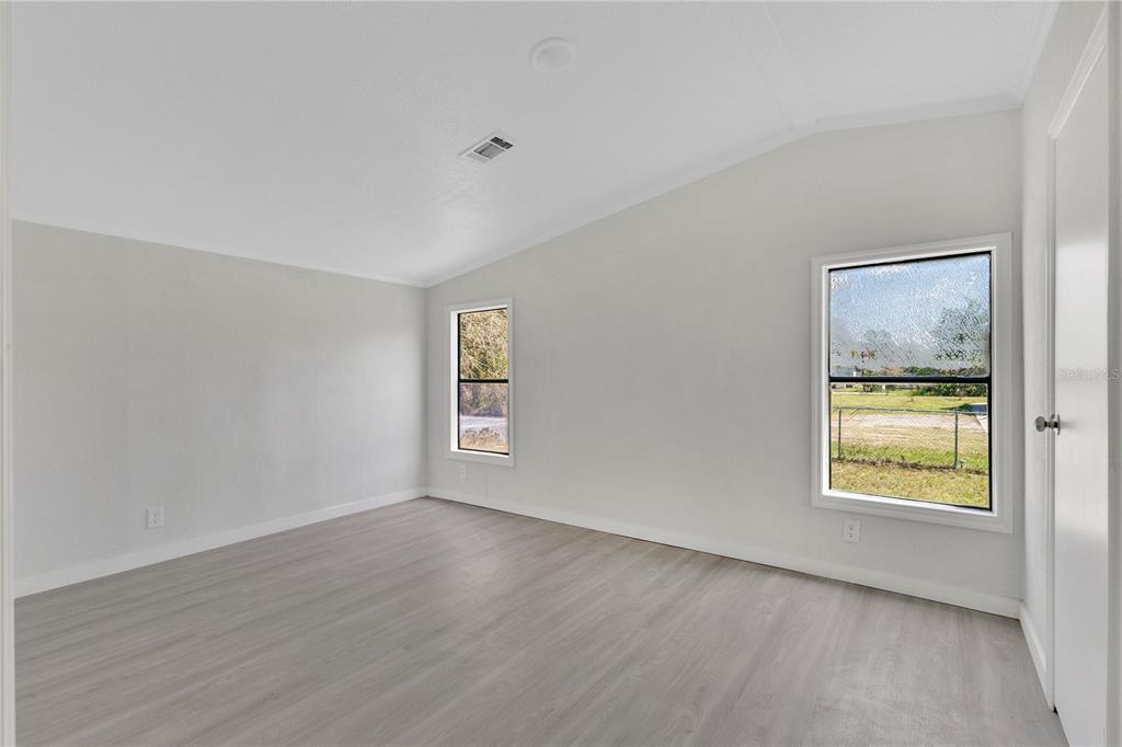 9180 Concord Road St. Cloud, FL 34773 - Photo 7 of 23 a view of an empty room with a window and wooden floor