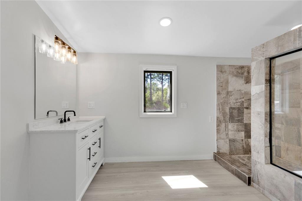 9180 Concord Road St. Cloud, FL 34773 - Photo 9 of 23 a bathroom with a sink mirror and shower