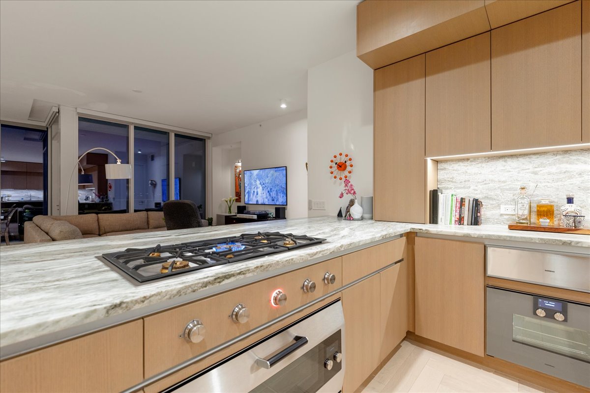 313 West 17th Street, Unit 1104 Austin, TX 78701 - Photo 15 of 40 A chef-inspired workstation anchored by the Gaggenau; 5-burner gas cooktop and upgraded 36” oven with blue enamel interior, all set within 3cm Fantasy Brown marble countertops. The open connection to the living area makes it ideal for Omakase-style dinners, interactive cooking, and effortless entertaining.
