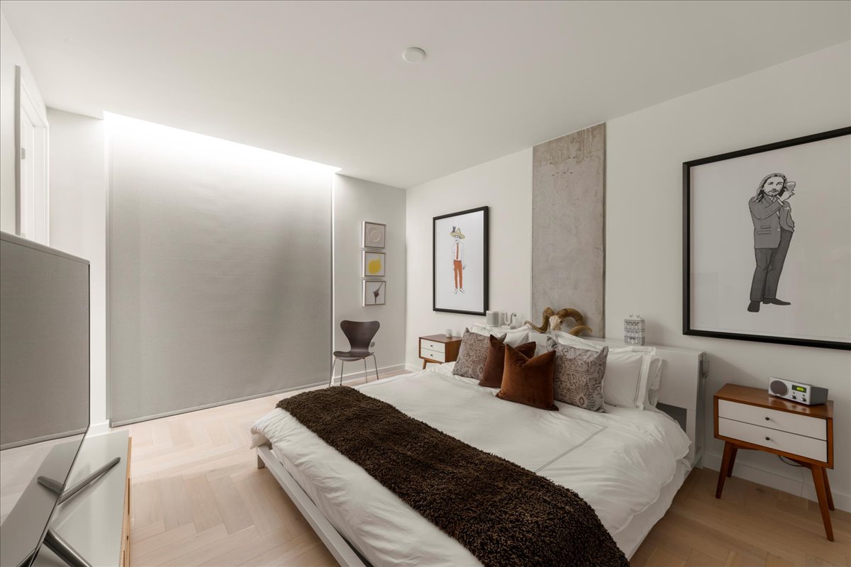 313 West 17th Street, Unit 1104 Austin, TX 78701 - Photo 17 of 40 Primary bedroom featuring wired, motorized blackout shades for effortless privacy and light control. A clean, modern setting enhanced by herringbone wood floors and thoughtful design details that elevate both comfort and daily living.