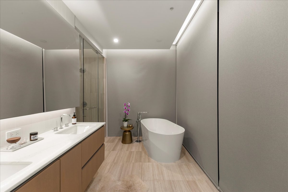 313 West 17th Street, Unit 1104 Austin, TX 78701 - Photo 19 of 40 Primary bath featuring wired, motorized blackout shades that provide effortless privacy and precise light control. A freestanding soaking tub, expansive double vanity and glass-enclosed shower complete this spa-inspired retreat, blending modern luxury with everyday convenience.