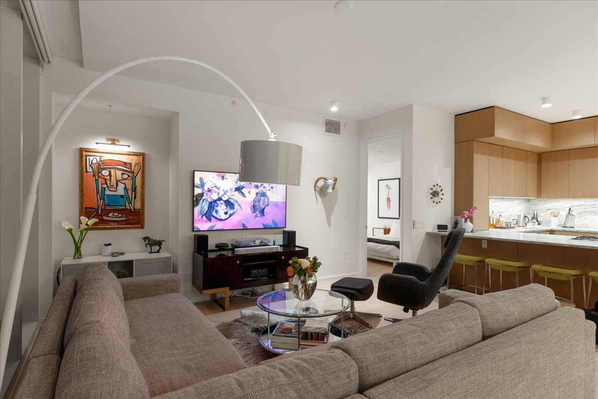 313 West 17th Street, Unit 1104 Austin, TX 78701 - Photo 10 of 40 Inviting living room with open flow to the kitchen and dining, featuring floor-to-ceiling windows, custom shades, and space designed for both relaxation and entertaining.