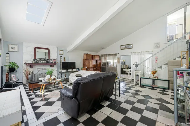 a living room with furniture and a dining table with kitchen view