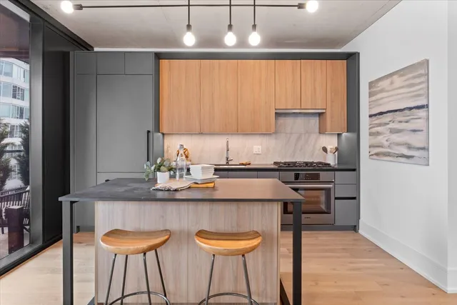 a kitchen with stainless steel appliances granite countertop a sink and a stove