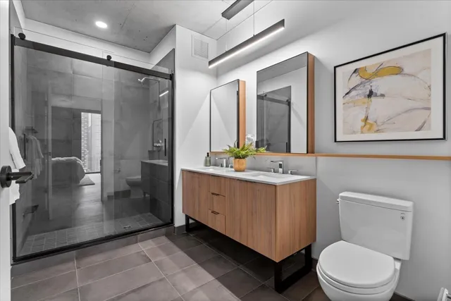 a bathroom with a double vanity sink toilet and shower