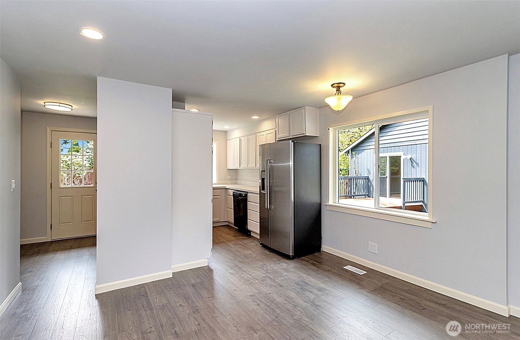 2325 Cherry Road, Unit B Lake Stevens, WA 98258 - Photo 6 of 13 an empty room with wooden floor and a kitchen