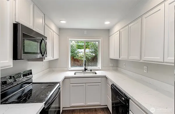 a kitchen with a sink stove and microwave