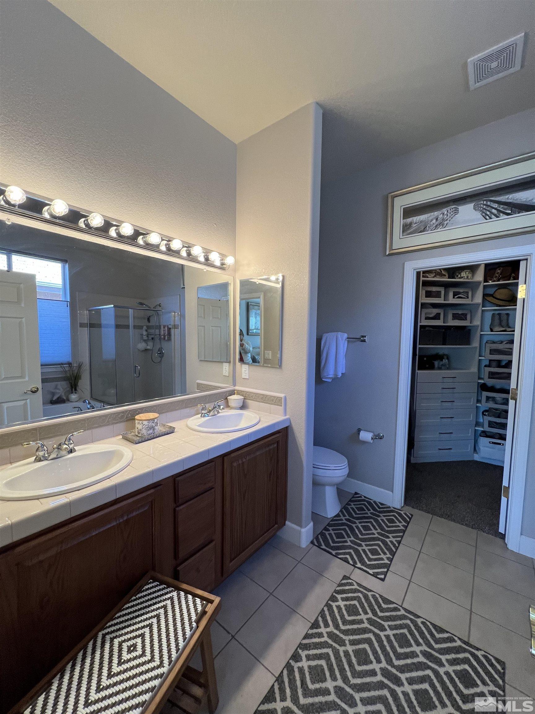 1085 Tee Drive Minden, NV 89423 - Photo 20 of 29 a spacious bathroom with a double vanity sink a toilet and a shower