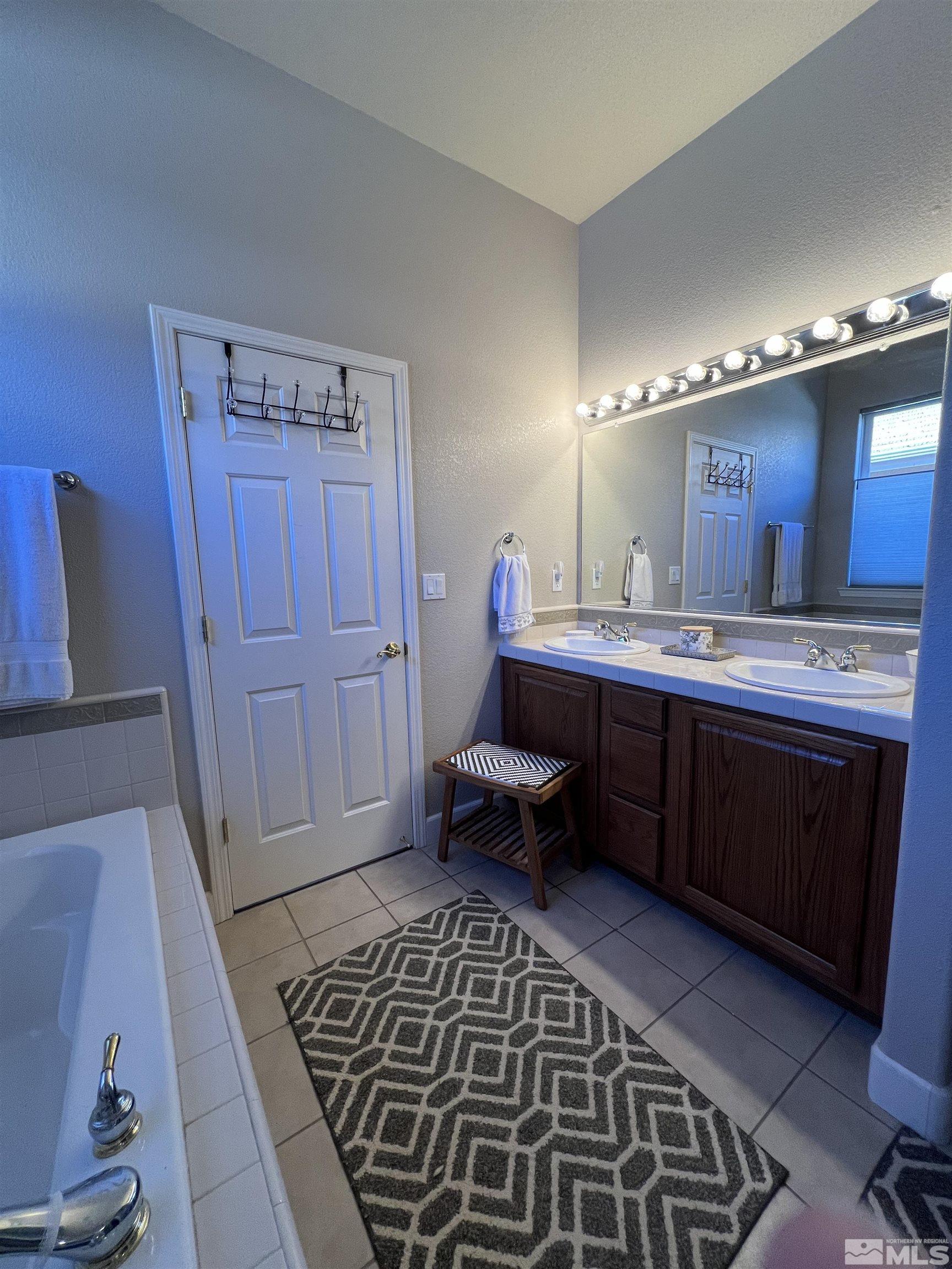 1085 Tee Drive Minden, NV 89423 - Photo 21 of 29 a en suite bathroom with a double vanity sink and a mirror