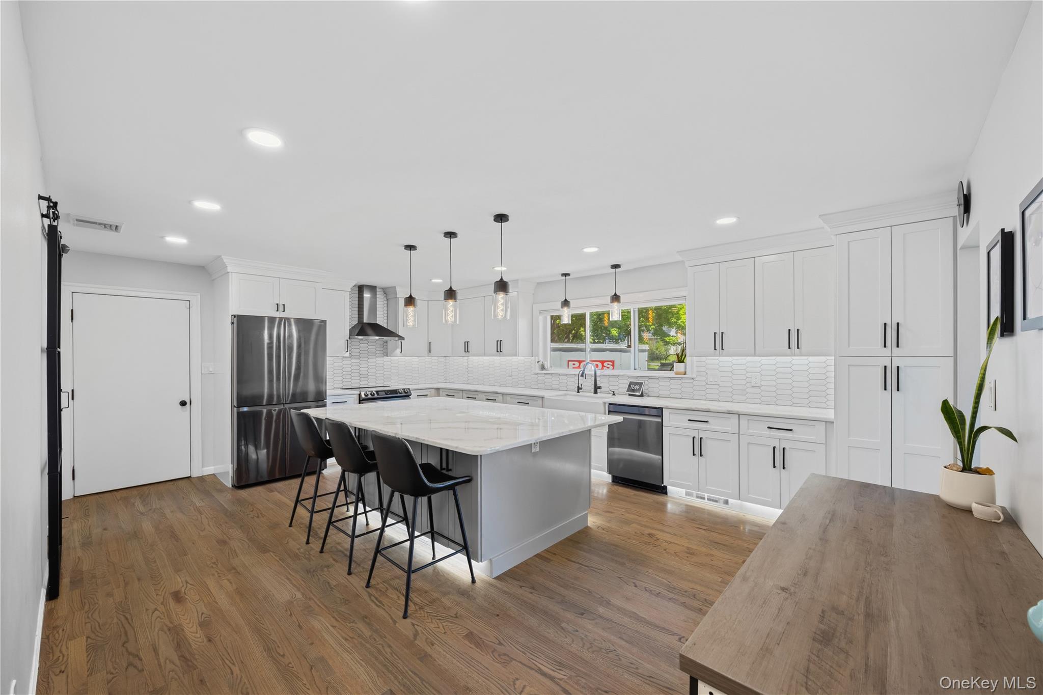 69 Silver Spring Road New Windsor, NY 12553 - Photo 4 of 20 a kitchen with a stove a sink dishwasher a refrigerator with white cabinets and wooden floor