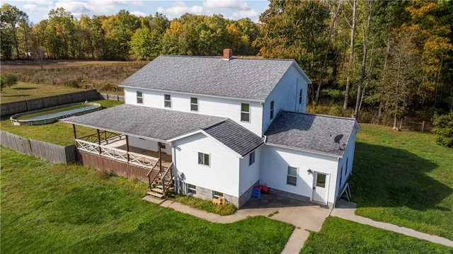 a aerial view of a house next to a big yard and large trees