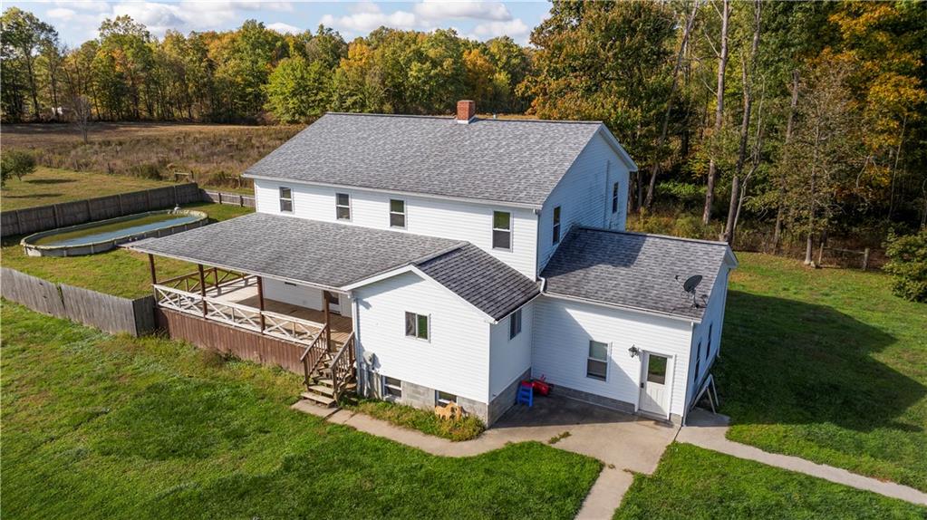 a aerial view of a house next to a big yard and large trees
