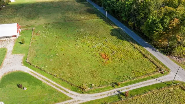 a view of a white house with a big yard and large trees