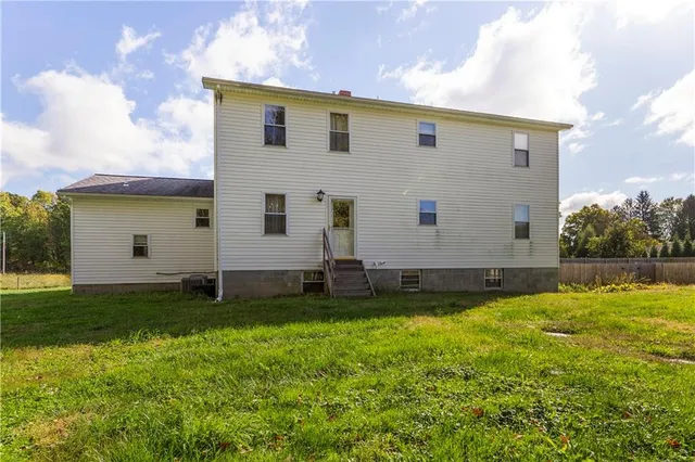 a view of a back yard with an tree and wooden fence