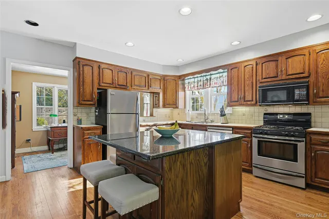 a kitchen with stainless steel appliances granite countertop a sink refrigerator and cabinets