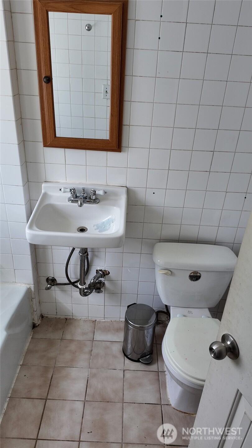 565 South Director Street Seattle, WA 98108 - Photo 33 of 34 a bathroom with a sink a toilet and a mirror