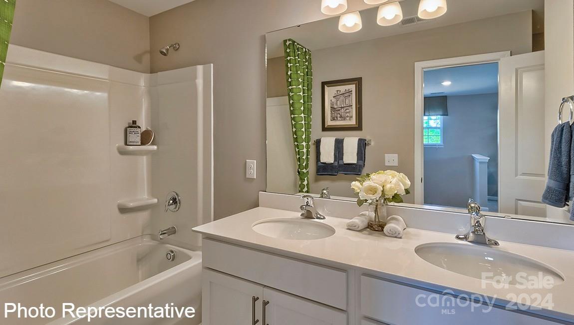 113 Dandelion Road Fletcher, NC 28732 - Photo 21 of 29 a bathroom with a granite countertop sink a mirror a bathtub and shower
