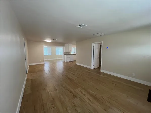 a view of empty room with wooden floor