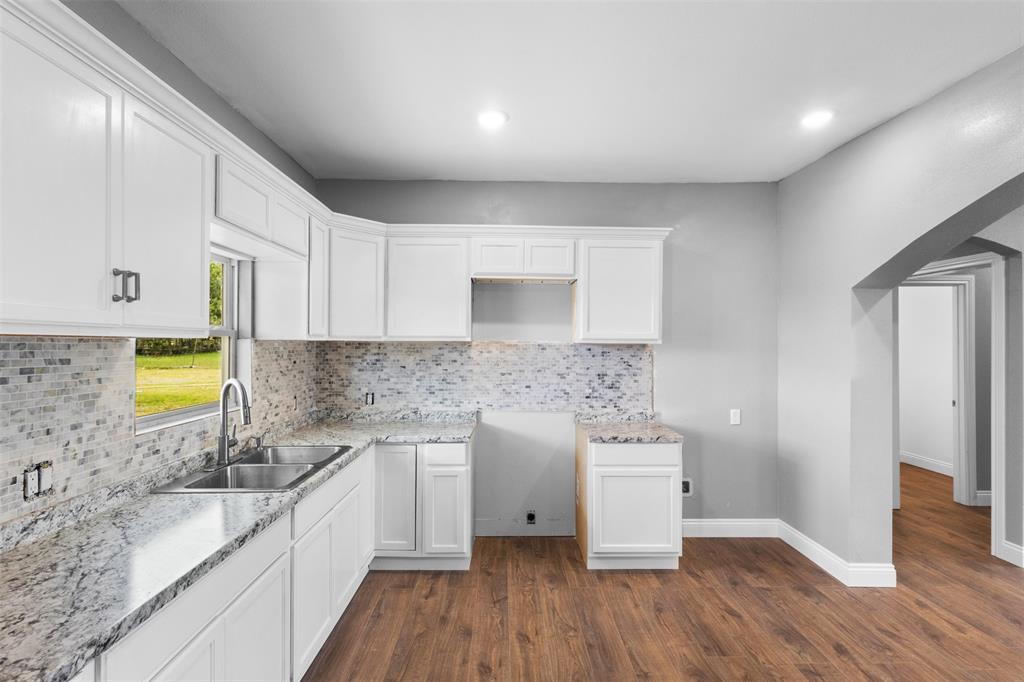 7074 Northeast County Road Rice, TX 75155 - Photo 6 of 22 a kitchen with a sink a stove cabinets and wooden floor