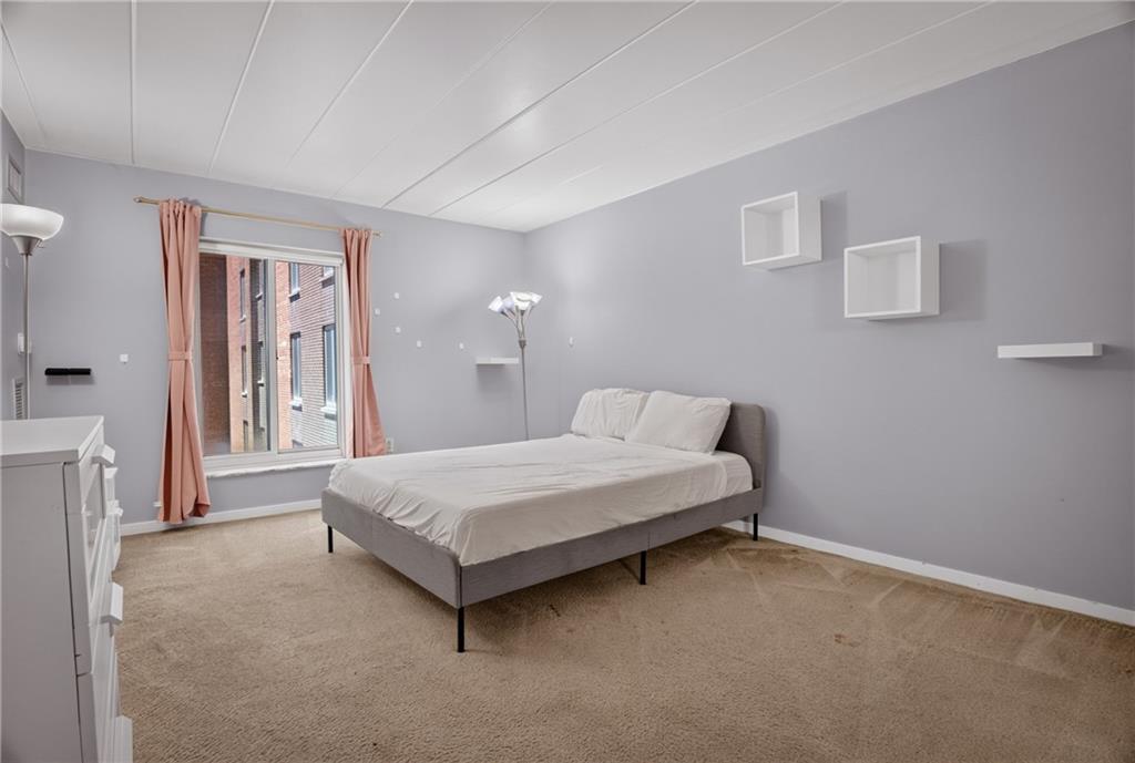 5 Bayard Road, Unit 309 Pittsburgh, PA 15213 - Photo 18 of 42 Serene primary bedroom offering brick city views, soft natural light, and generous proportions.