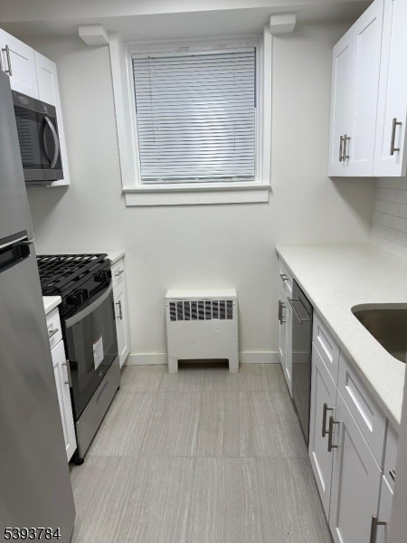 604 Chestnut Street, Unit C Union, NJ 07083 - Photo 8 of 10 a kitchen with a sink a stove and cabinets