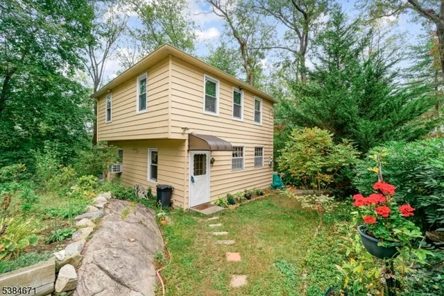 a view of a house with small yard and a large tree