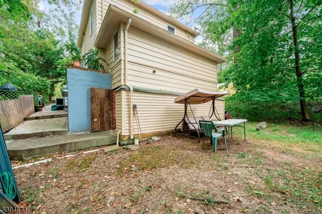 a view of a house with backyard and sitting area