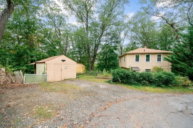 a view of a house with a yard and large trees