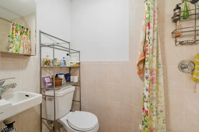 a white toilet sitting next to a bathroom sink and a shower