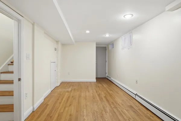 a view of empty room with wooden floor