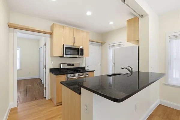 a kitchen with stainless steel appliances granite countertop a sink a stove and a refrigerator